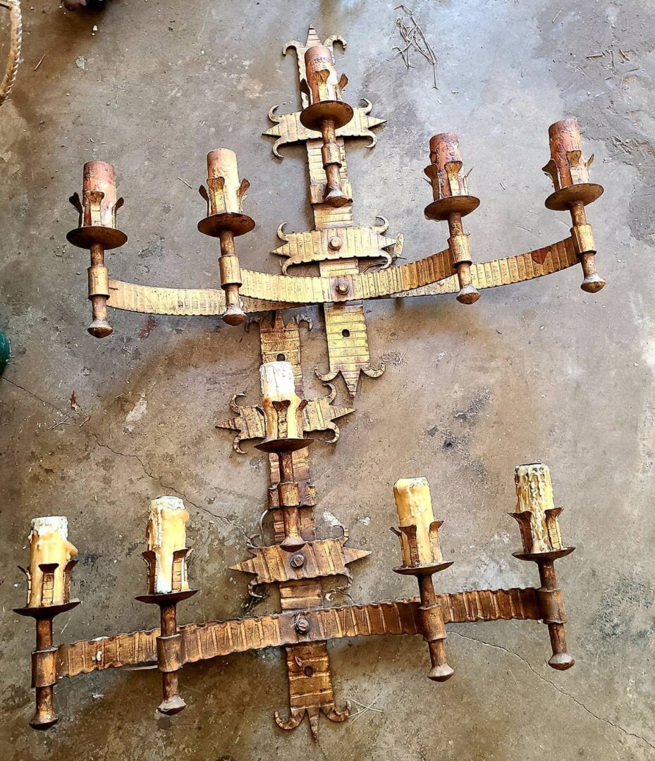 Rustic metal candle sconce assembly on concrete
