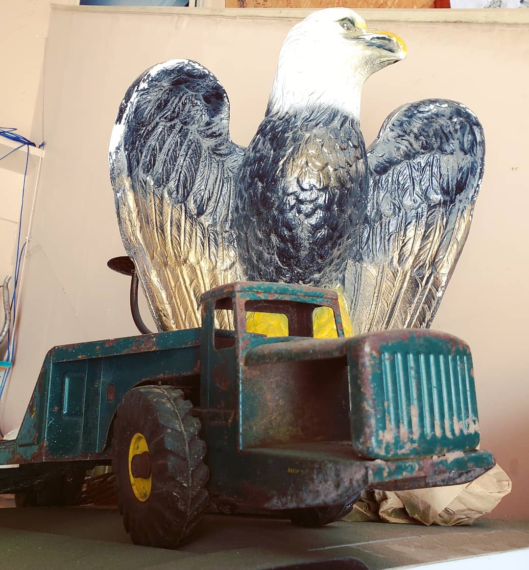 Eagle sculpture behind vintage toy truck