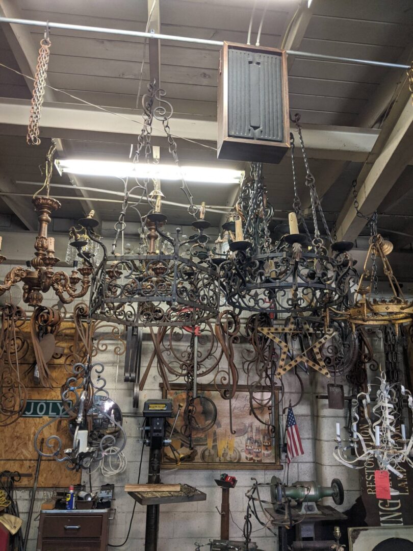 Ornate wrought iron chandeliers hanging in workshop
