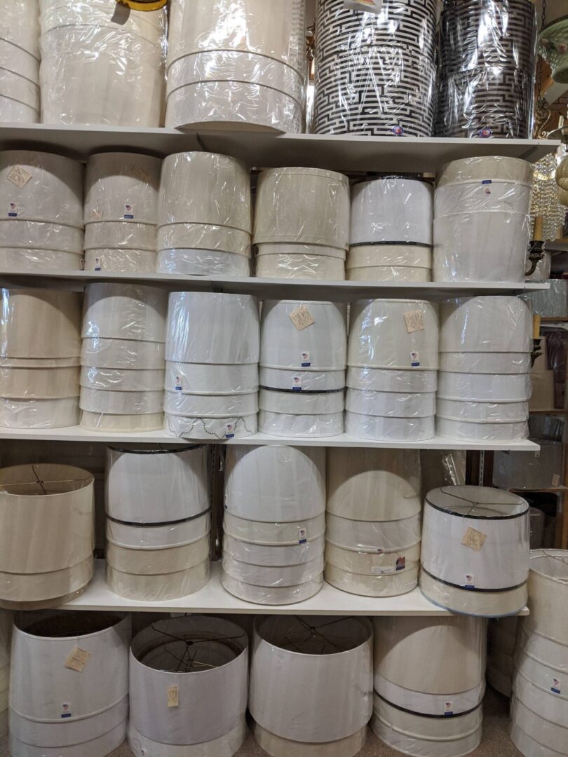 Stacked white drum lamp shades on shelves